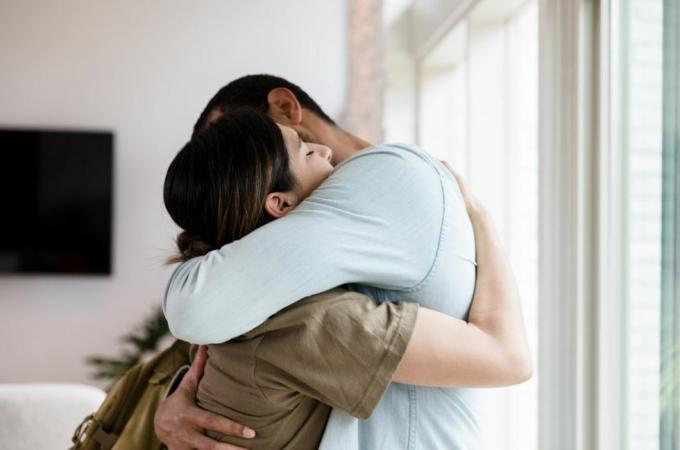 trist mid voksen kvinnelig soldat klemmer mannen sin farvel når hun drar til militærtjeneste