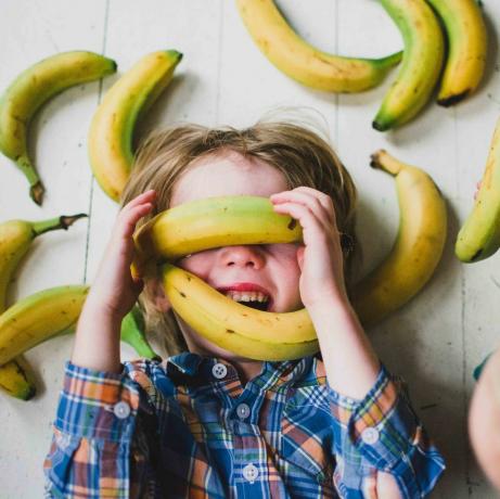 Barn (2-3, 4-5) dekket av bananer