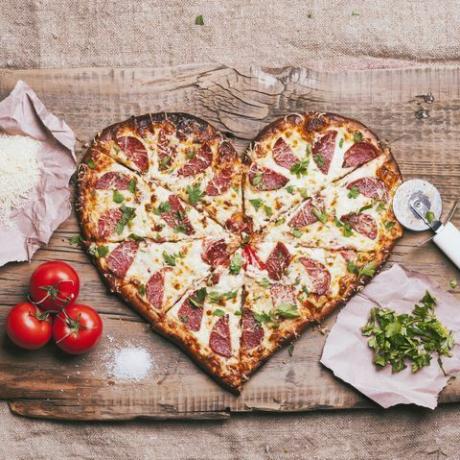 hjerteformet pizza og ingredienser på skjærebrett