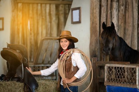 kvinner kledd i cowboykostyme med hest i bakgrunnen