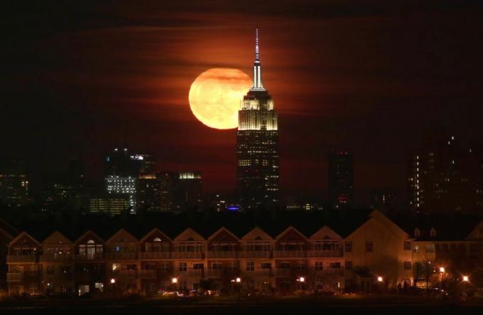 Fullmåne stiger bak Empire State Building i New York City