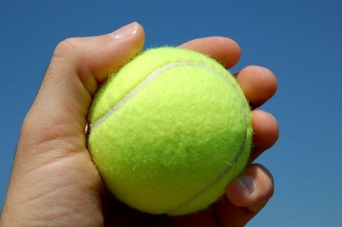 Tennisball i hånden på nært hold