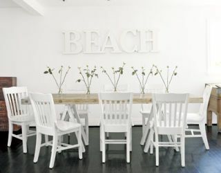 uformell spisestue med klappstoler og strand med hvite bokstaver på veggen