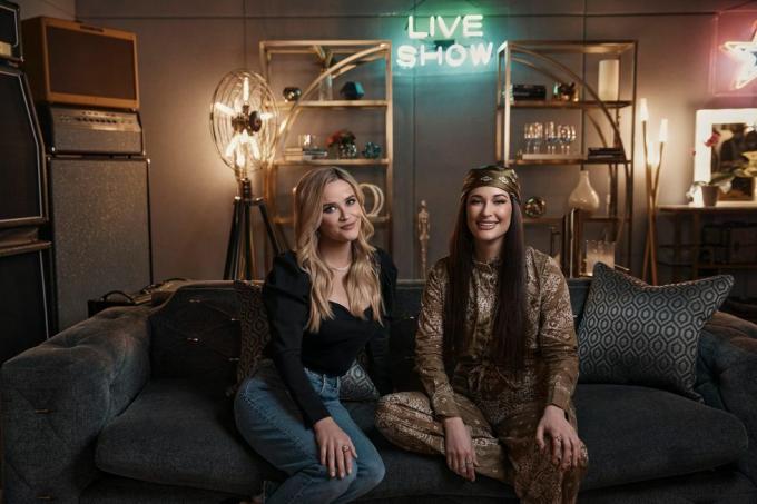 reese witherspoon og kacey musgraves sitter ved siden av hverandre på sofaen