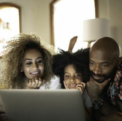 lykkelig familie som ser på film på en bærbar datamaskin