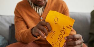nærbilde av afrikansk amerikansk mann åpningsbrev til pappa som håndlaget gave til farsdag, kopirom