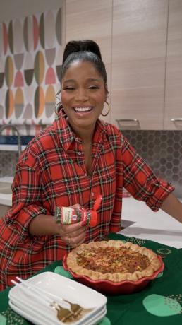 keke palmer drysser persille på quiche ved kjøkkenbenken