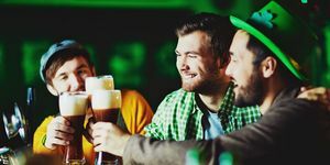 glade gutter med glass skummende øl tilbringer tid på pub