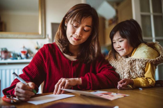 mor datter forbereder gratulasjonskort for familien hjemme