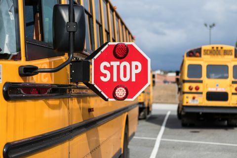 skolebussjåfør som sjekker flere aspekter av bussen før rute