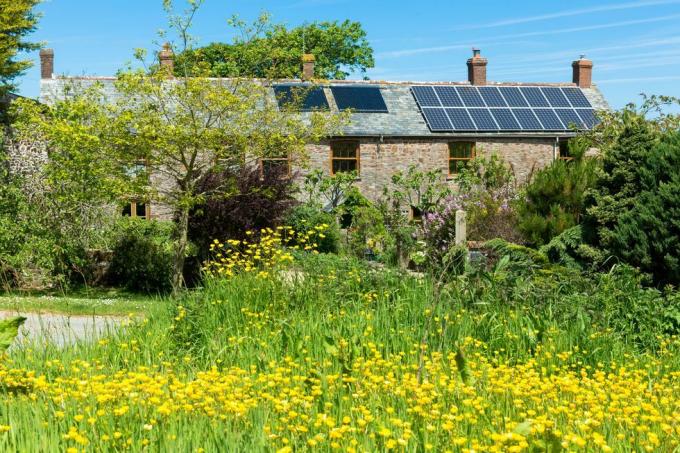 solcellepaneler og takvarmeveksler for varmt vann på en tidstypisk eiendom i Cornwall, Sør-England, Storbritannia