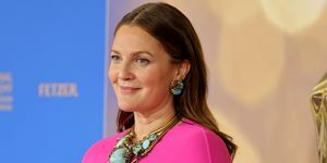 Drew Barrymore iført en rosa kjole med kappe og turkise smykker på dagtid Emmy Award rød løper