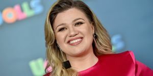 kelly clarkson smiler i rosa kjole og firkantede svarte øredobber